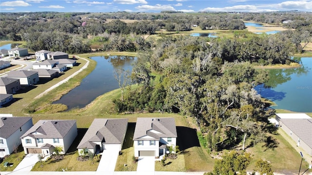 bird's eye view featuring a residential view, a wooded view, and a water view