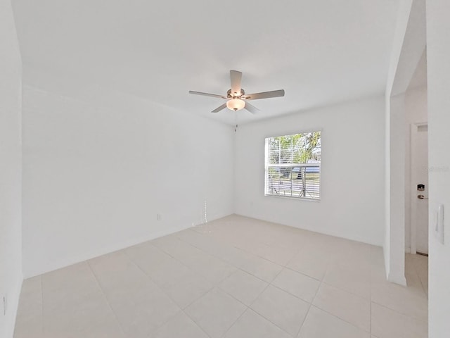 tiled spare room featuring ceiling fan