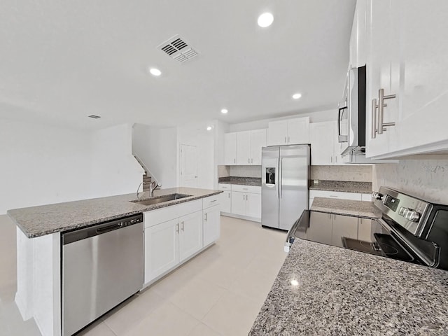 kitchen featuring sink, white cabinets, an island with sink, stone countertops, and appliances with stainless steel finishes