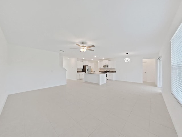 unfurnished living room featuring ceiling fan and light tile patterned floors