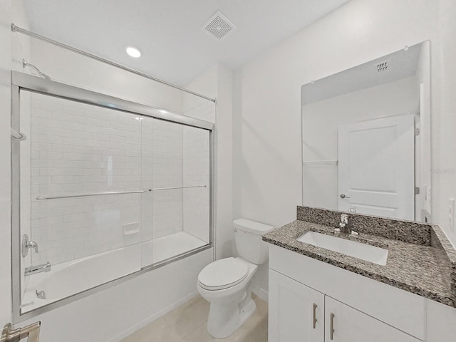 full bathroom with toilet, tile patterned floors, vanity, and bath / shower combo with glass door