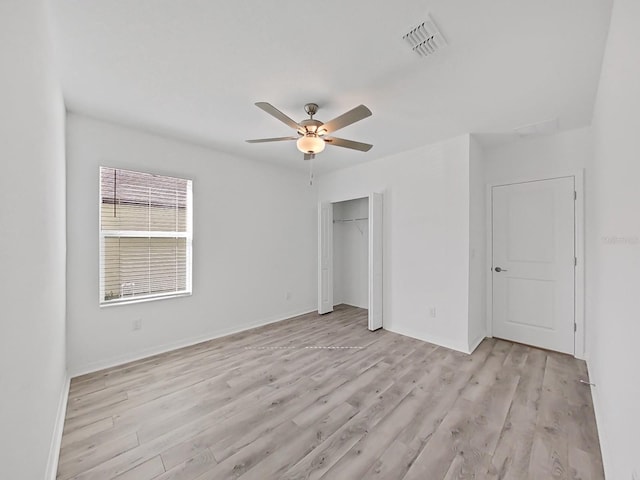 unfurnished bedroom featuring light wood-type flooring, ceiling fan, and a closet