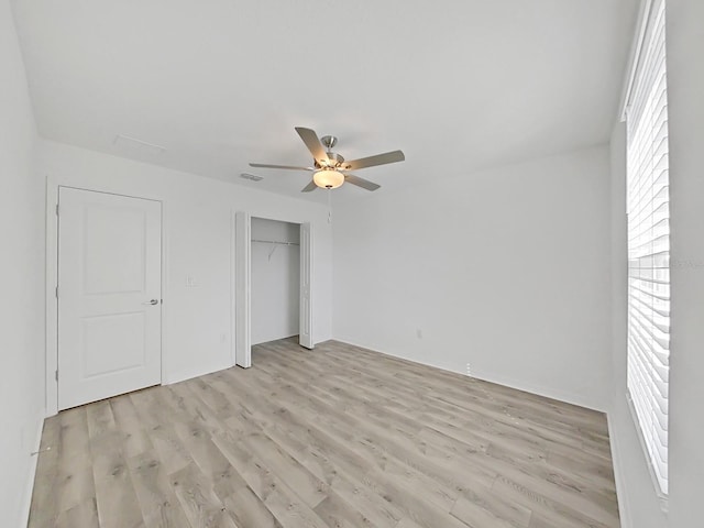 unfurnished bedroom featuring a closet, ceiling fan, and light wood-type flooring