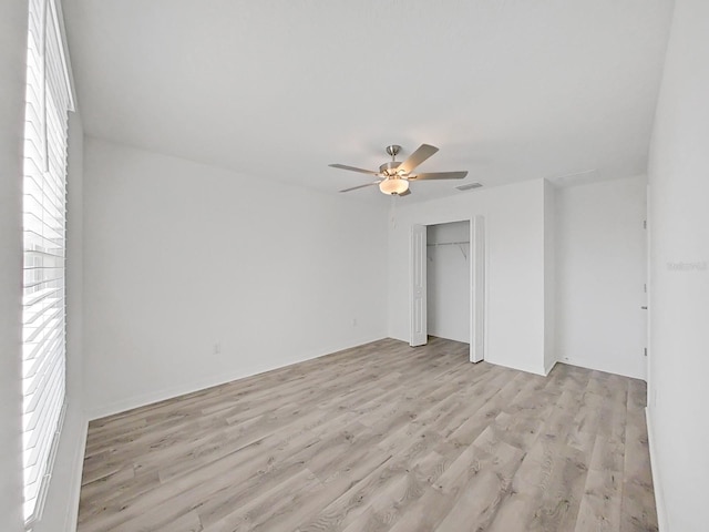 unfurnished bedroom with ceiling fan, light wood-type flooring, and a closet