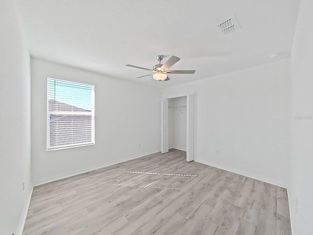 unfurnished bedroom with ceiling fan, light wood-type flooring, and a closet