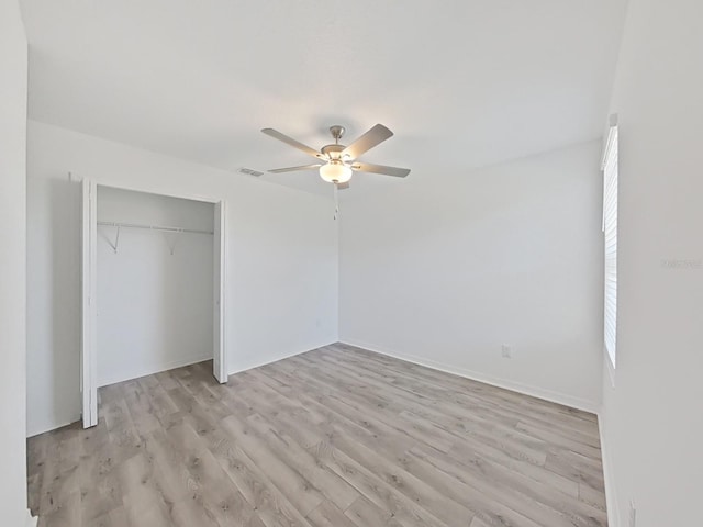 unfurnished bedroom featuring ceiling fan, light hardwood / wood-style flooring, and a closet