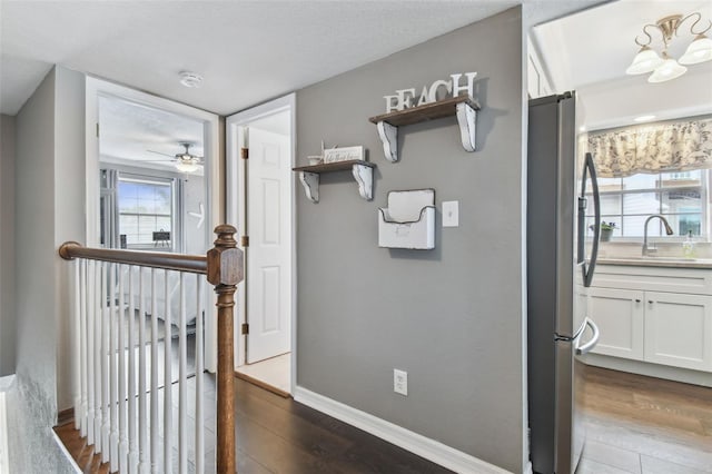 hallway featuring sink, dark hardwood / wood-style floors, and a notable chandelier