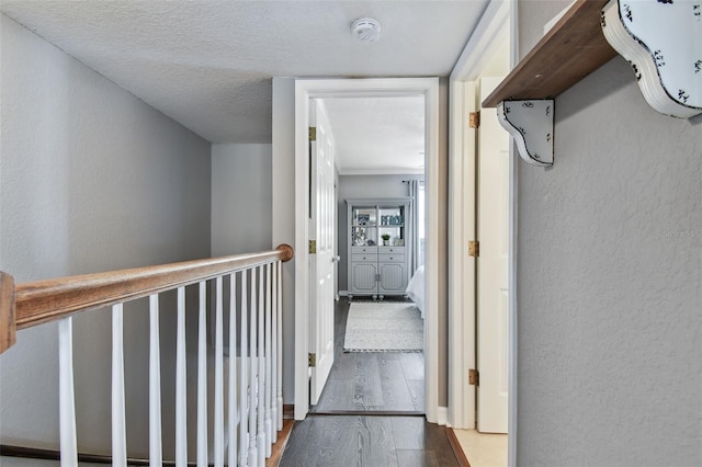 corridor featuring dark wood-type flooring and a textured ceiling