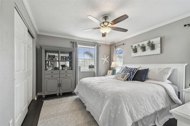 bedroom with a textured ceiling, ceiling fan, dark hardwood / wood-style floors, and ornamental molding