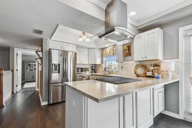 kitchen featuring island range hood, kitchen peninsula, white cabinetry, and appliances with stainless steel finishes