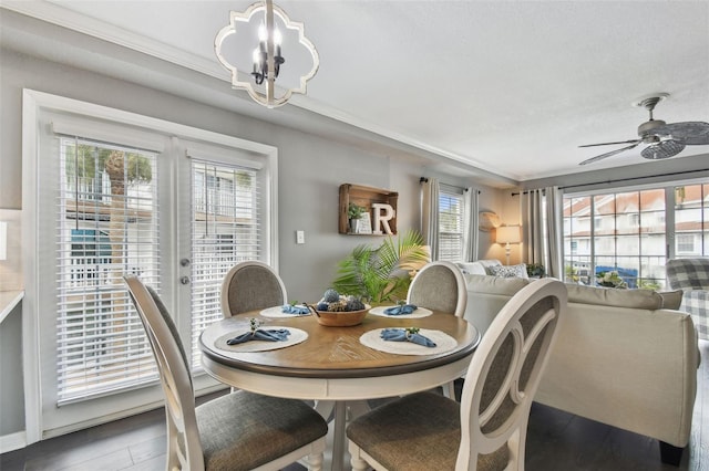 dining area with ceiling fan with notable chandelier and crown molding