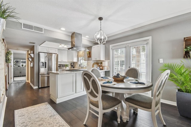 dining space with dark hardwood / wood-style flooring, a textured ceiling, crown molding, and sink