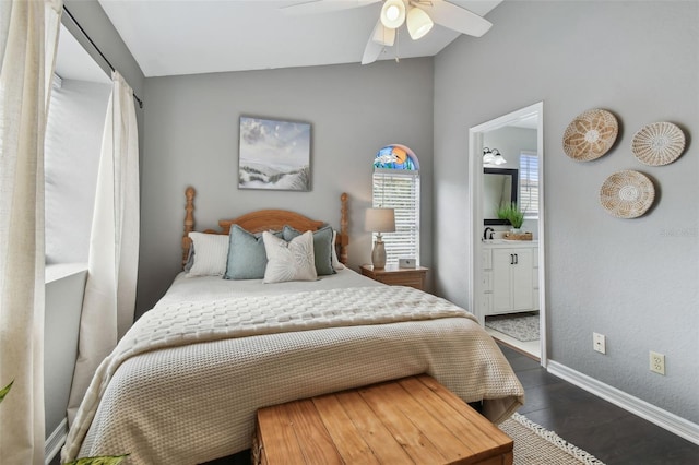 bedroom featuring ensuite bath, ceiling fan, dark wood-type flooring, and vaulted ceiling