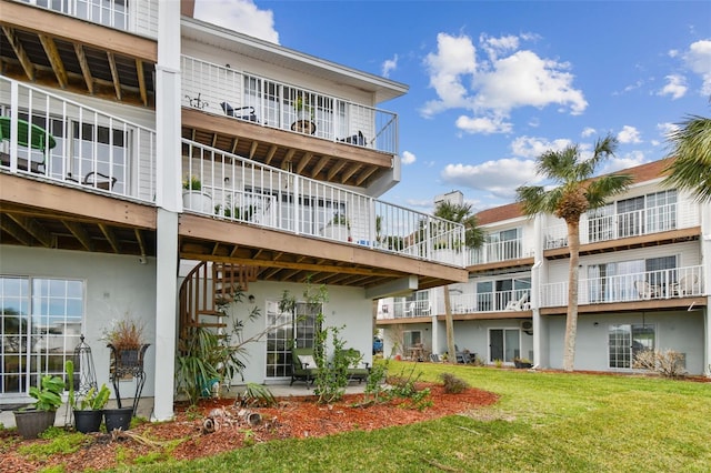 rear view of property featuring a lawn