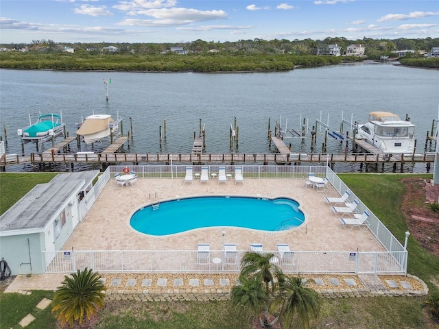 view of swimming pool with a patio area, a water view, and a boat dock