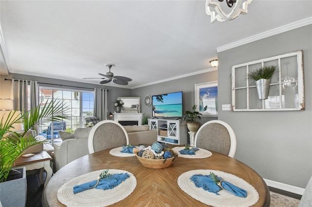 dining space featuring ceiling fan with notable chandelier and ornamental molding