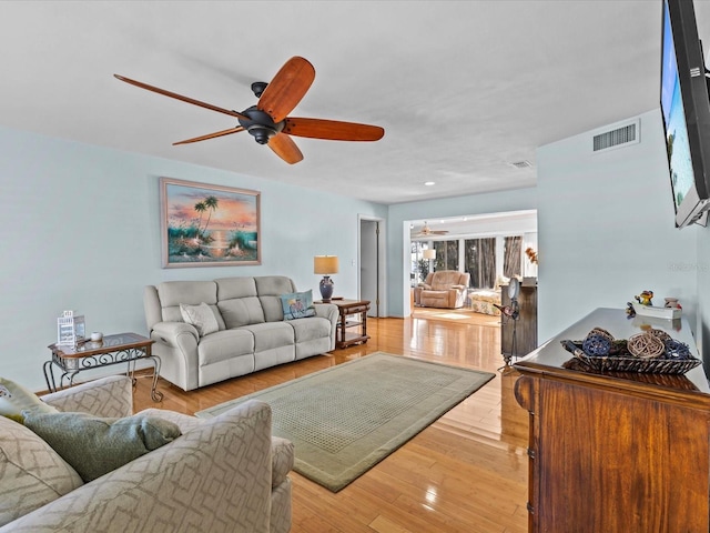 living room featuring hardwood / wood-style floors and ceiling fan