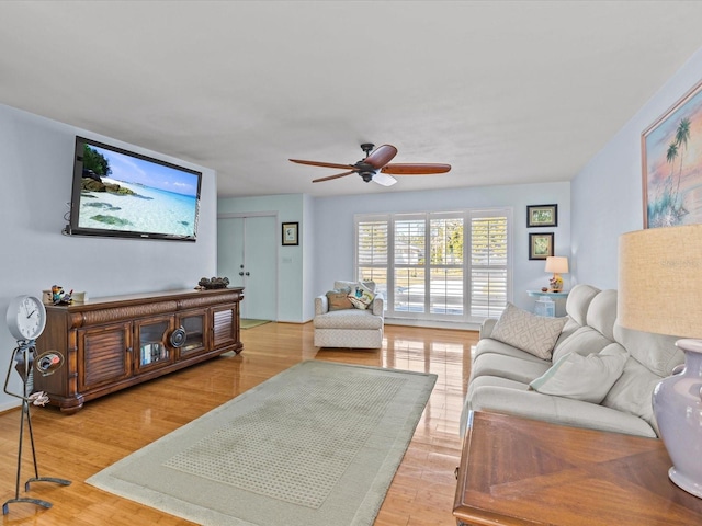 living room with light wood-type flooring and ceiling fan