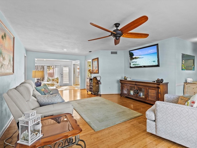 living room featuring ceiling fan and hardwood / wood-style flooring