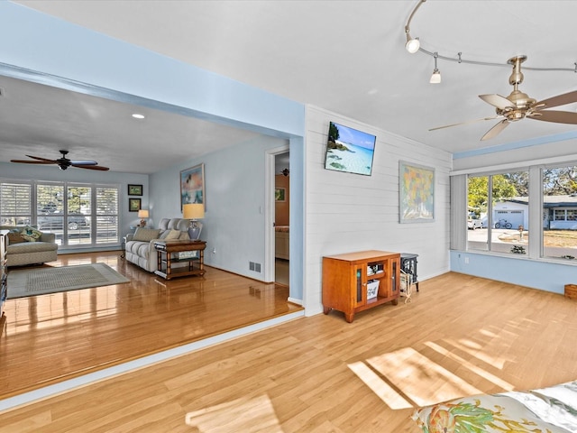 living room featuring ceiling fan and light hardwood / wood-style floors