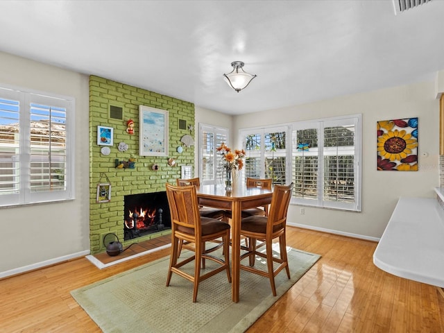 dining area featuring a fireplace and light wood-type flooring