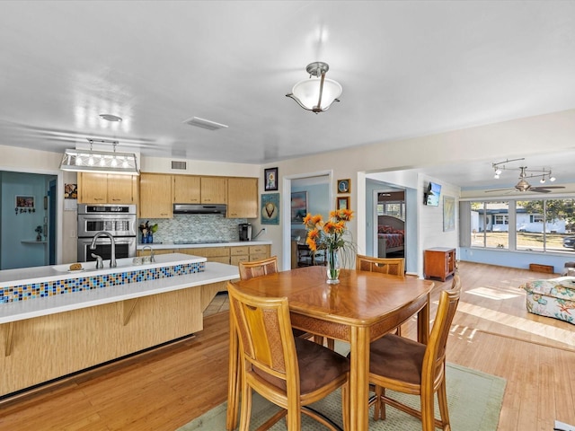 dining room with light wood-type flooring and sink