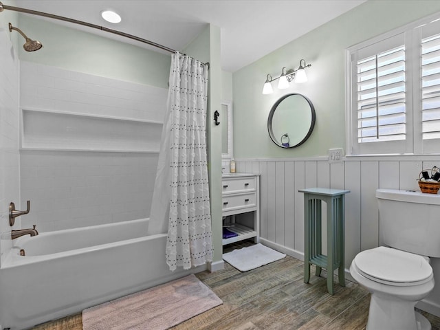 bathroom with shower / bath combo with shower curtain, hardwood / wood-style floors, and toilet