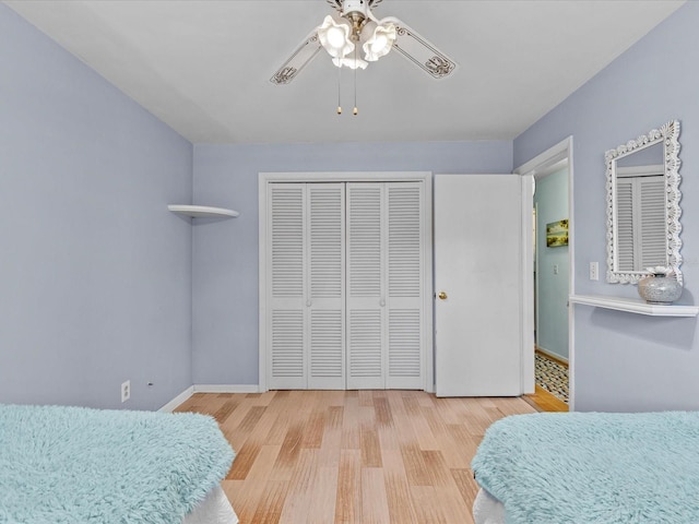 bedroom featuring ceiling fan, light wood-type flooring, and a closet