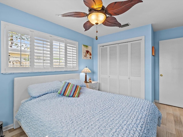 bedroom featuring light wood-type flooring, a closet, and ceiling fan