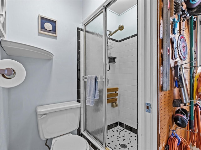 bathroom featuring toilet and a shower with door