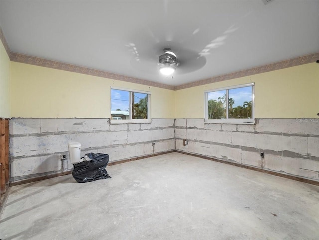 basement featuring ceiling fan and a wealth of natural light