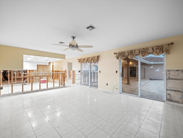 spare room featuring ceiling fan, light tile patterned floors, and a wealth of natural light