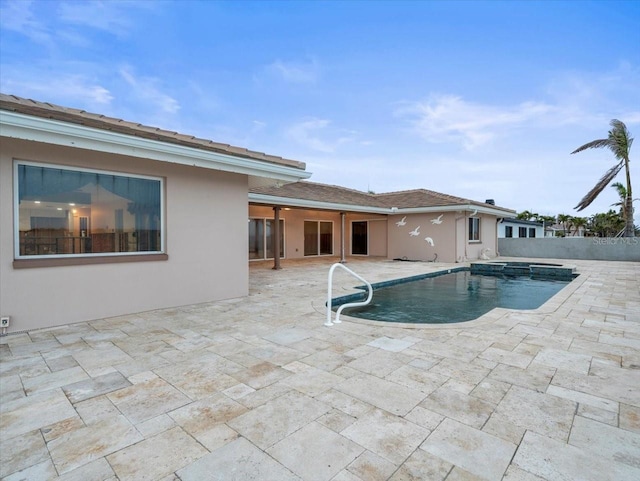 view of swimming pool featuring a patio and an in ground hot tub