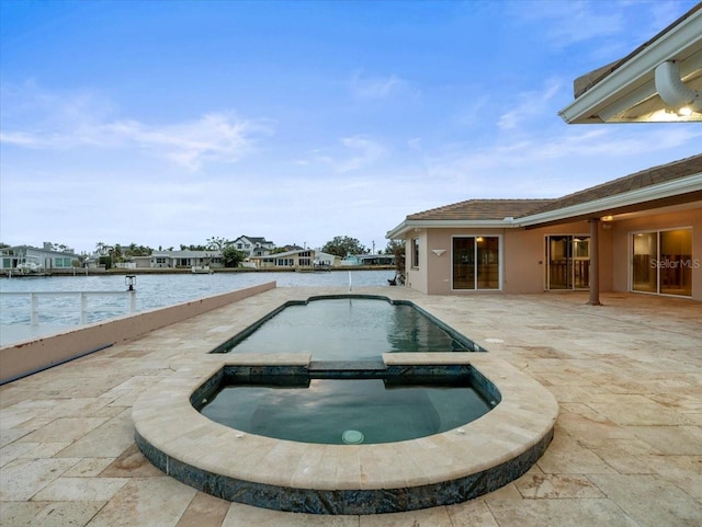 view of swimming pool with a patio area, an in ground hot tub, and a water view