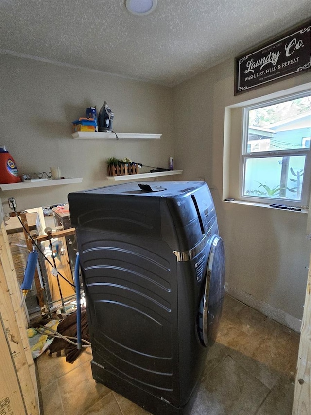 clothes washing area featuring tile patterned floors, separate washer and dryer, and a textured ceiling