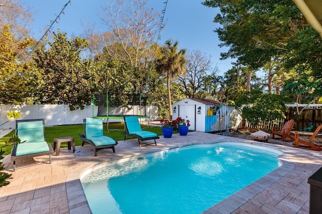 view of swimming pool featuring a shed, a trampoline, and a patio