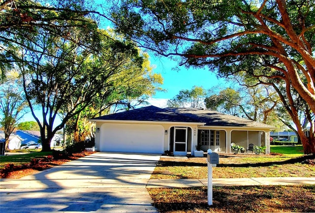 ranch-style home featuring a garage, concrete driveway, a front yard, and stucco siding