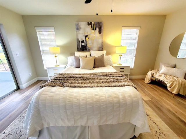 bedroom featuring access to outside, ceiling fan, light wood-style flooring, and baseboards