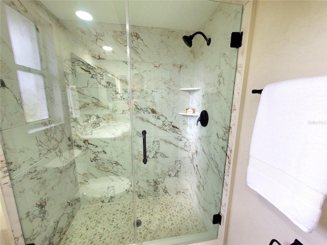 bathroom featuring a marble finish shower