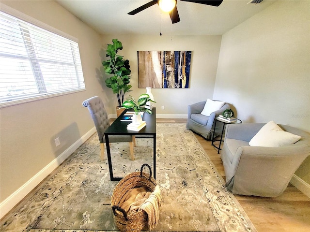 office space featuring visible vents, wood finished floors, a ceiling fan, and baseboards