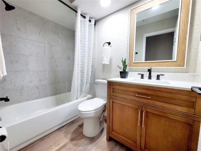 bathroom featuring shower / bath combo, a textured wall, toilet, wood finished floors, and vanity