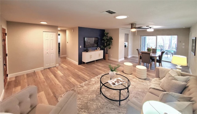 living area featuring ceiling fan, visible vents, light wood-style flooring, and baseboards