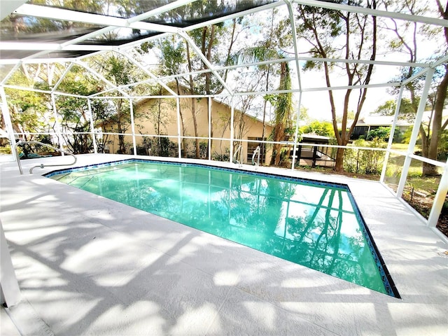 outdoor pool featuring a patio area and glass enclosure