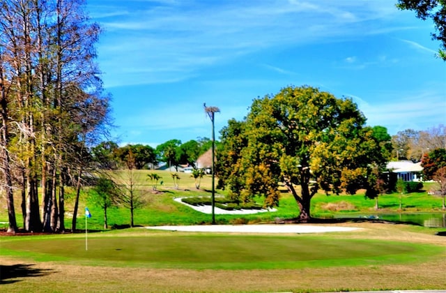 surrounding community featuring view of golf course and a lawn