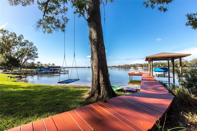 dock area with a water view and a yard