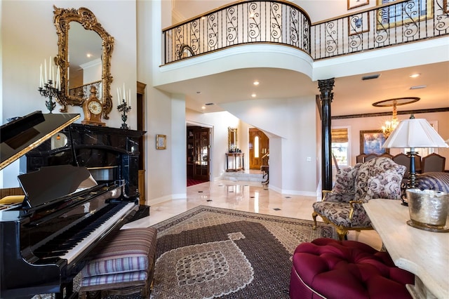 interior space featuring a high ceiling, an inviting chandelier, and ornate columns