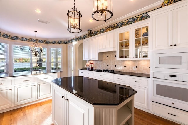 kitchen with white cabinets, white appliances, and hanging light fixtures