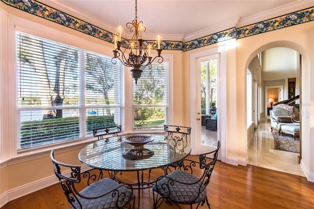 dining room with a chandelier, dark hardwood / wood-style flooring, plenty of natural light, and ornamental molding