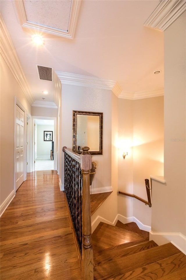 stairway with hardwood / wood-style flooring and crown molding