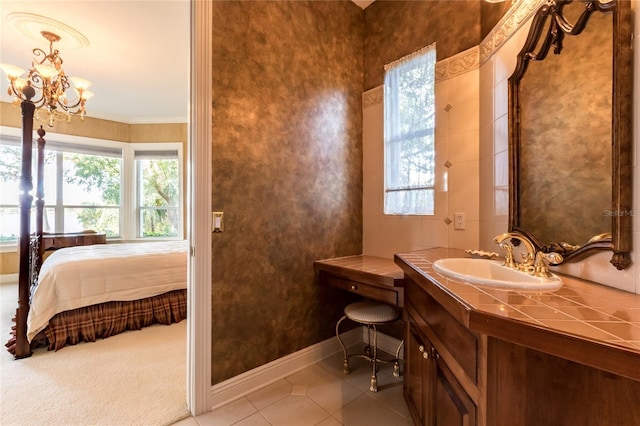 bathroom with tile patterned floors, vanity, an inviting chandelier, and ornamental molding